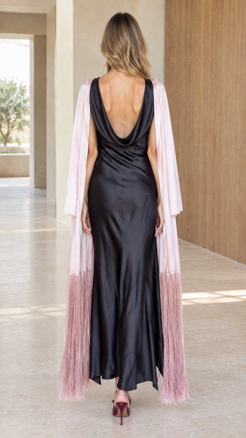 Back view of black cowl-back satin maxi dress and blush pink duster with fringe hem