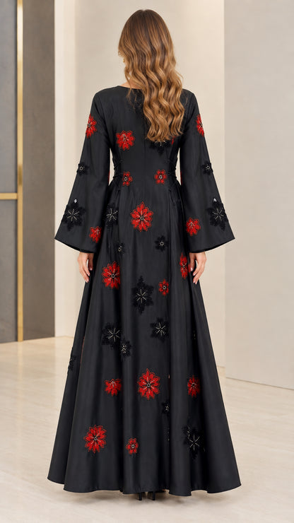 Back view of black A-line maxi dress with flared sleeves and floral accents