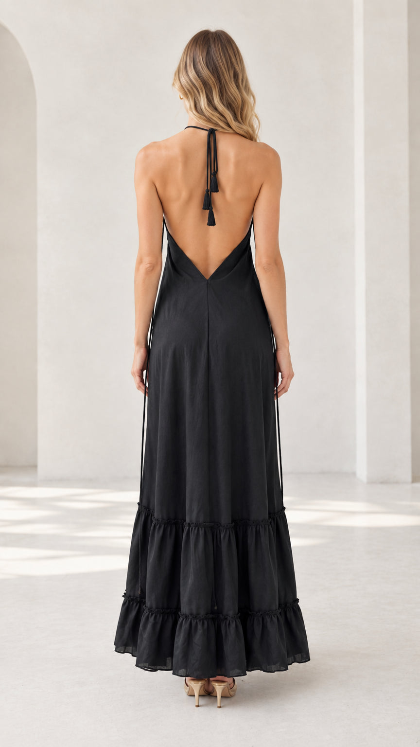 Back view of model showing low back design on black halter maxi dress