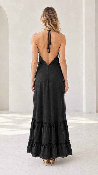 Back view of model showing low back design on black halter maxi dress