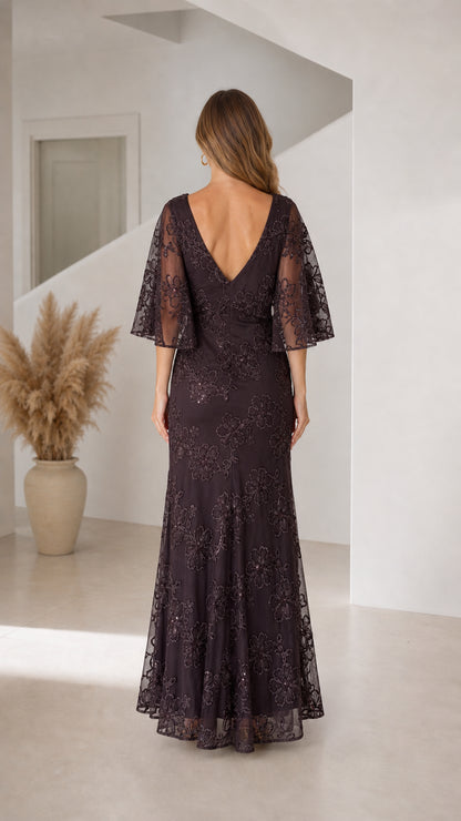 Back view of woman wearing dark plum flutter sleeve evening dress with V-back