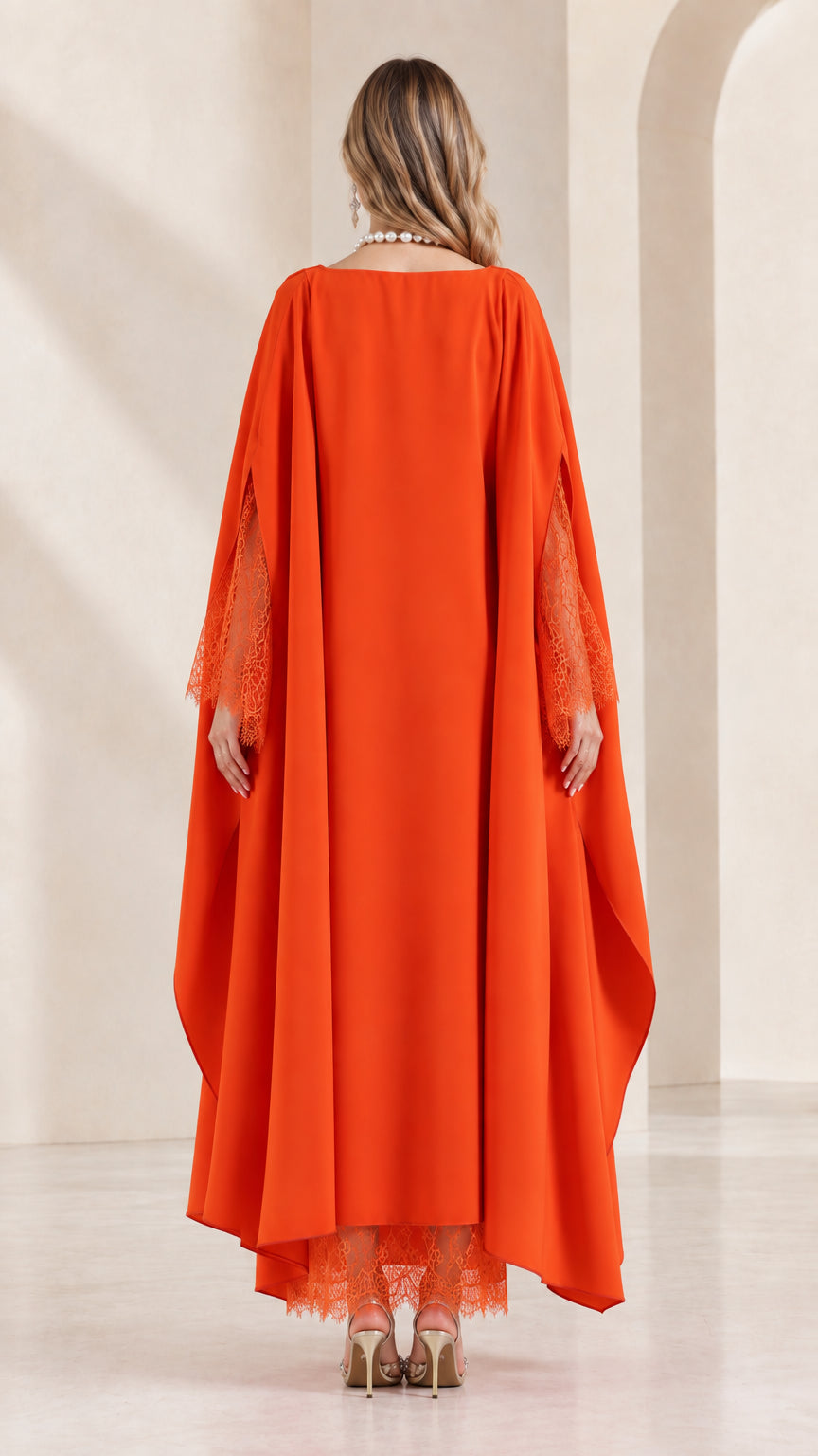 Back view of woman wearing draped orange cape kaftan dress