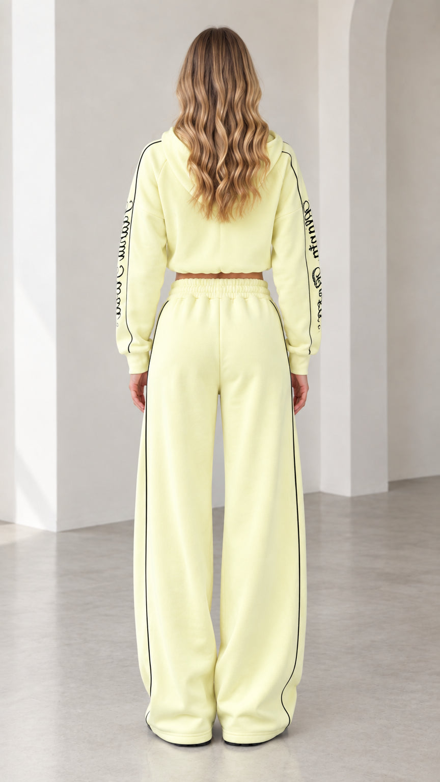 Back view of model wearing butter yellow hooded tracksuit set with wide-leg pants