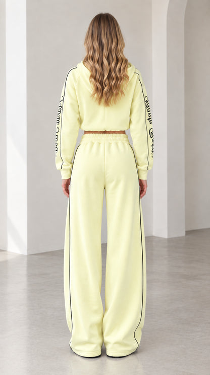 Back view of model wearing butter yellow hooded tracksuit set with wide-leg pants