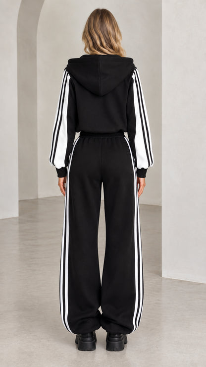 Back view of model wearing black hooded cropped track jacket and matching sweatpants