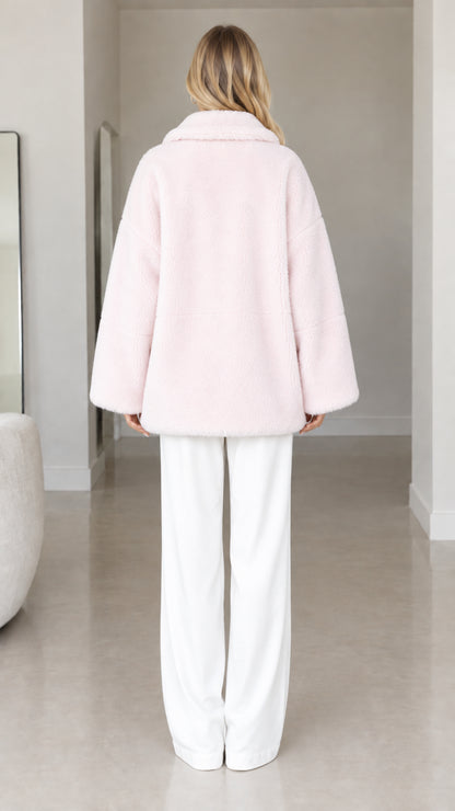 Back view of model wearing pale pink relaxed fit faux fur coat