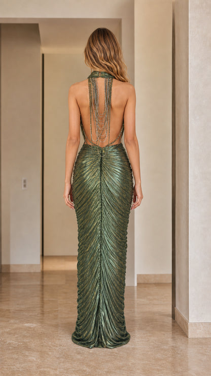 Back view of woman showcasing dramatic open back and draped halter strap detail in olive green gown