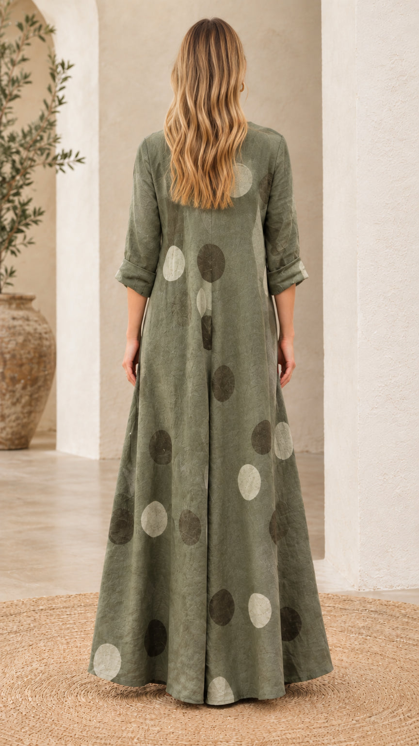 Back view of woman wearing flowing sage green polka dot maxi dress