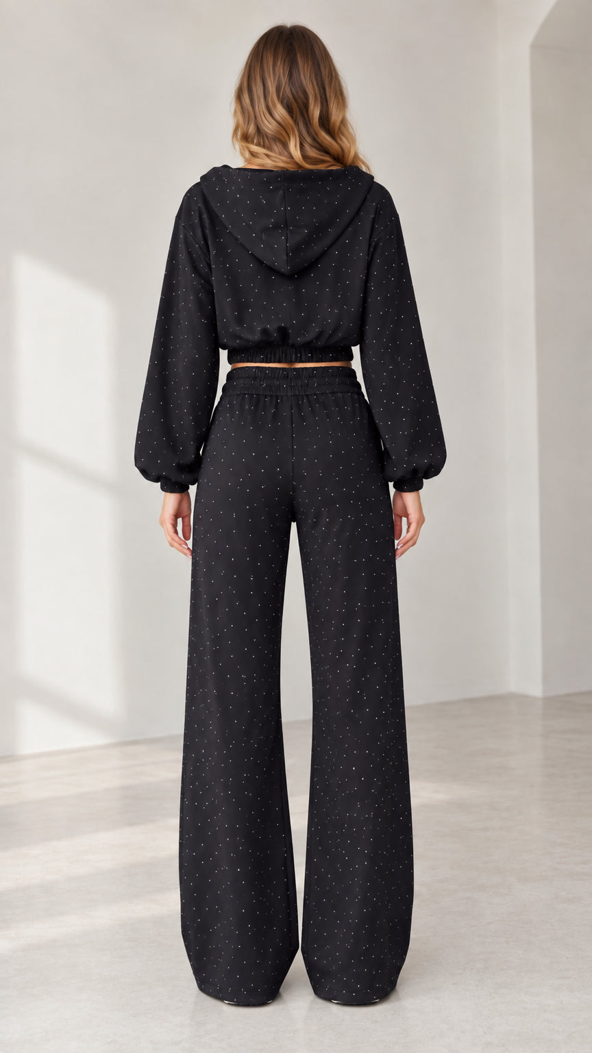 Back view of model wearing black hooded 3-piece tracksuit with wide-leg pants