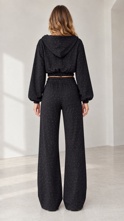 Back view of model wearing black hooded 3-piece tracksuit with wide-leg pants