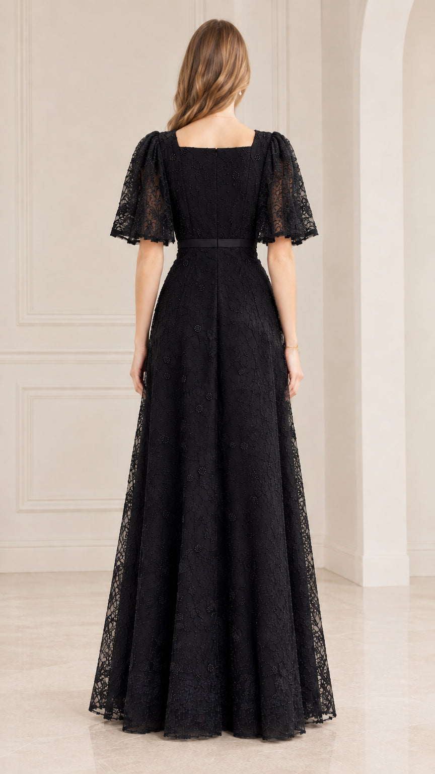 Back view of model wearing black square neckline floor-length lace dress