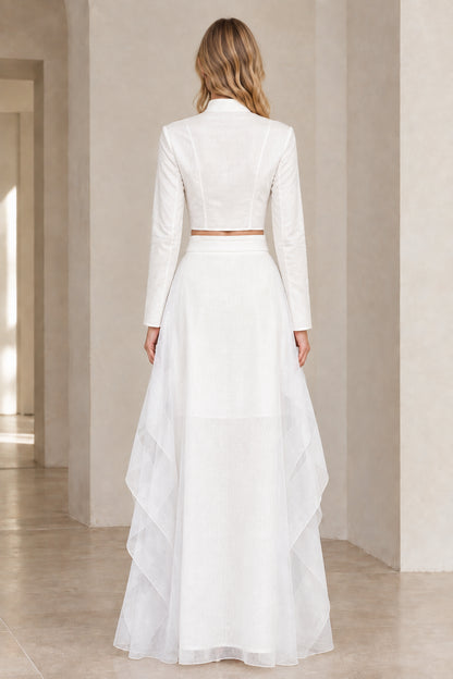 Back view of model wearing white long-sleeve crop top and flowy maxi skirt