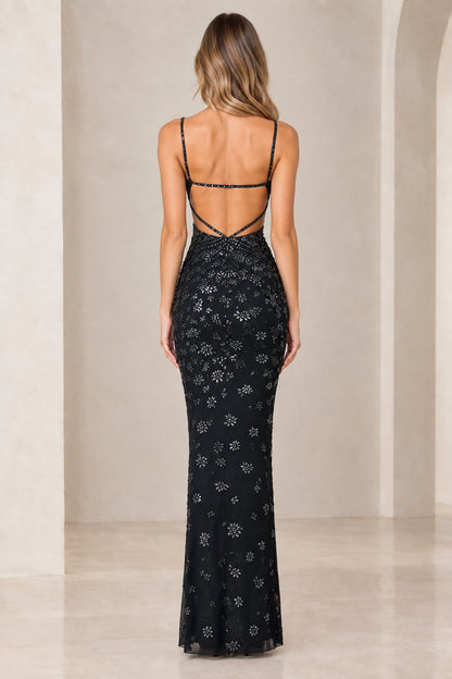 Back view of model showcasing low back strap detail of black gown