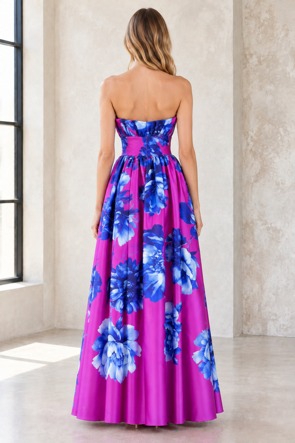 Back view of model wearing magenta strapless floral evening dress