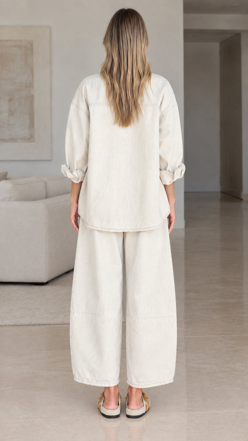 Back view of women's relaxed fit matching shirt and pants set in cream