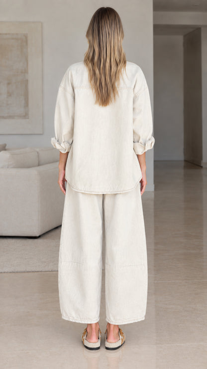 Back view of women's relaxed fit matching shirt and pants set in cream