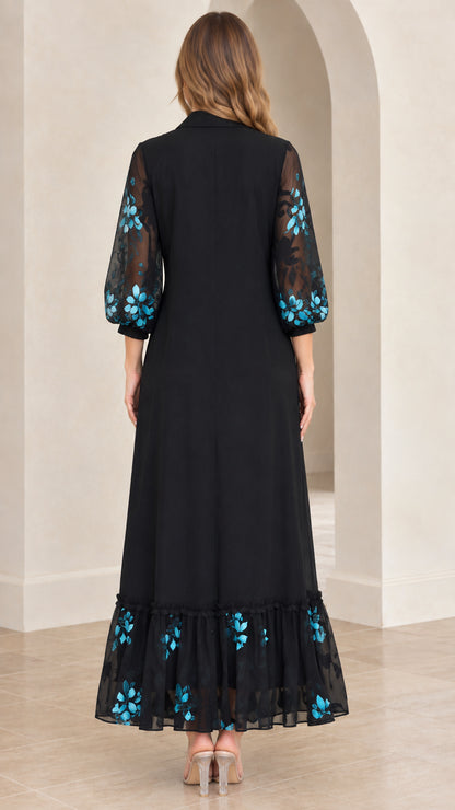 Back view of black maxi dress showing sheer embroidered 3/4 sleeves and tiered hem