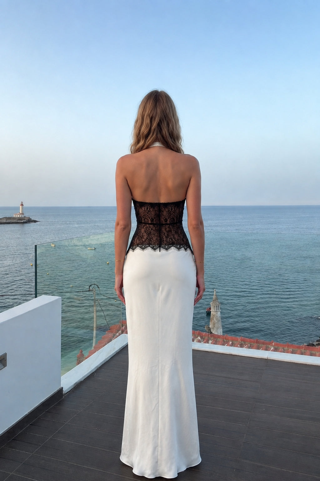 Back view of model in white satin halter dress showing backless cut and lace midriff