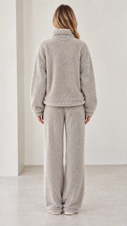Back view of model wearing light gray fleece pullover and wide-leg pants