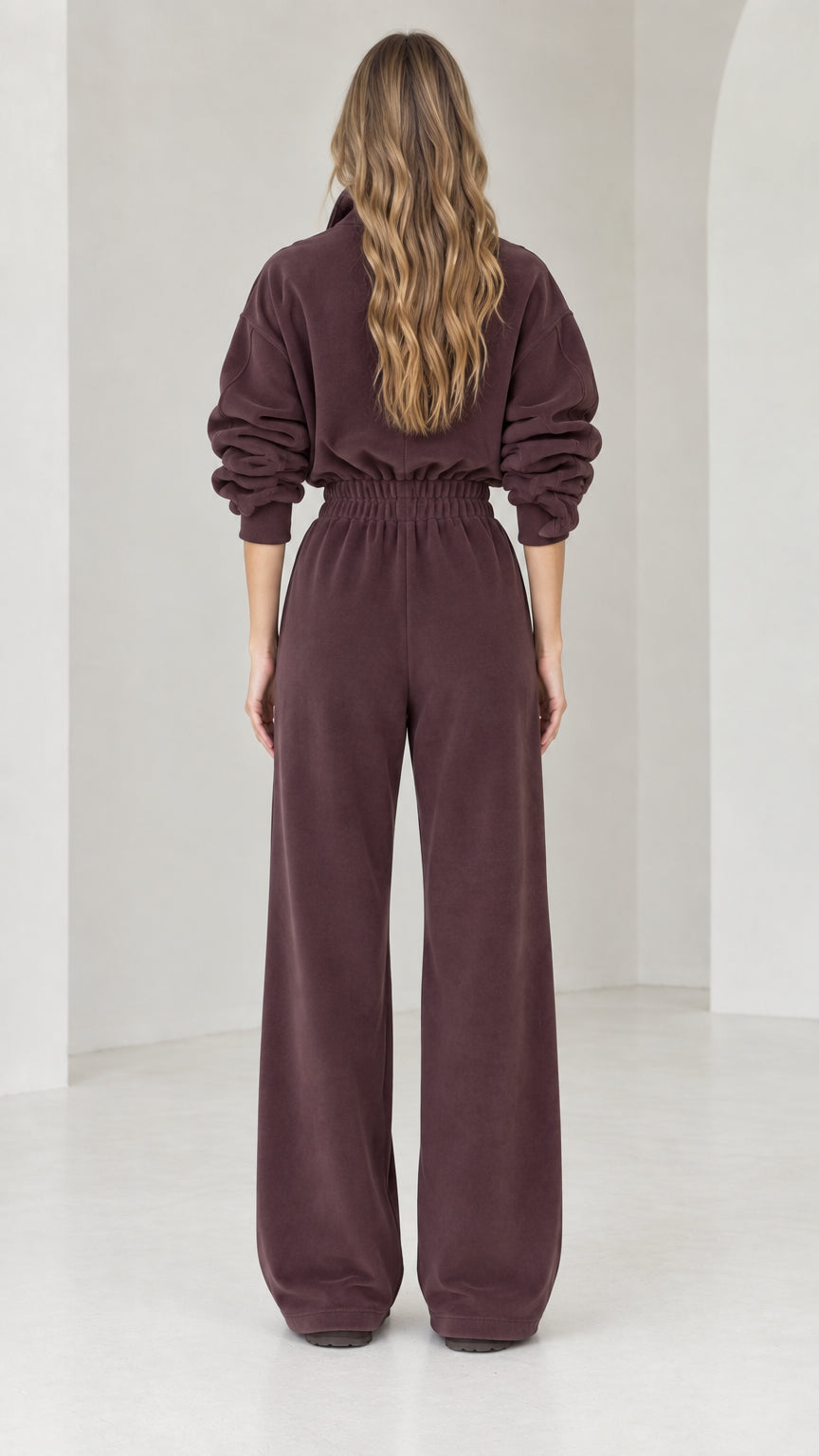 Back view of model wearing chocolate brown half-zip wide leg fleece jumpsuit