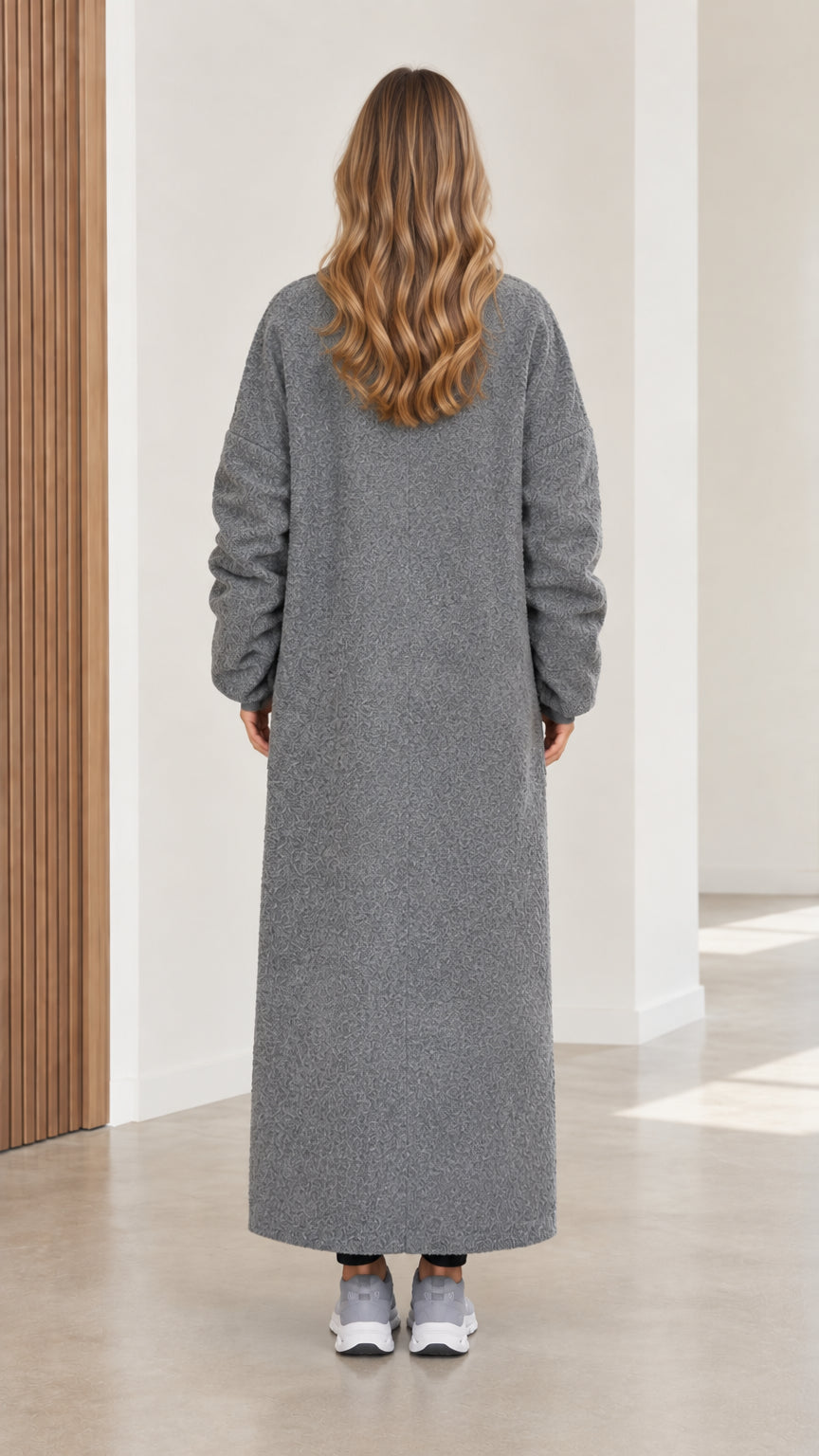 Back view of women's long grey duster coat showing center seam