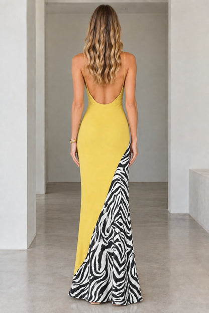 Back view of model showing the low back cut of the yellow maxi dress with zebra panel