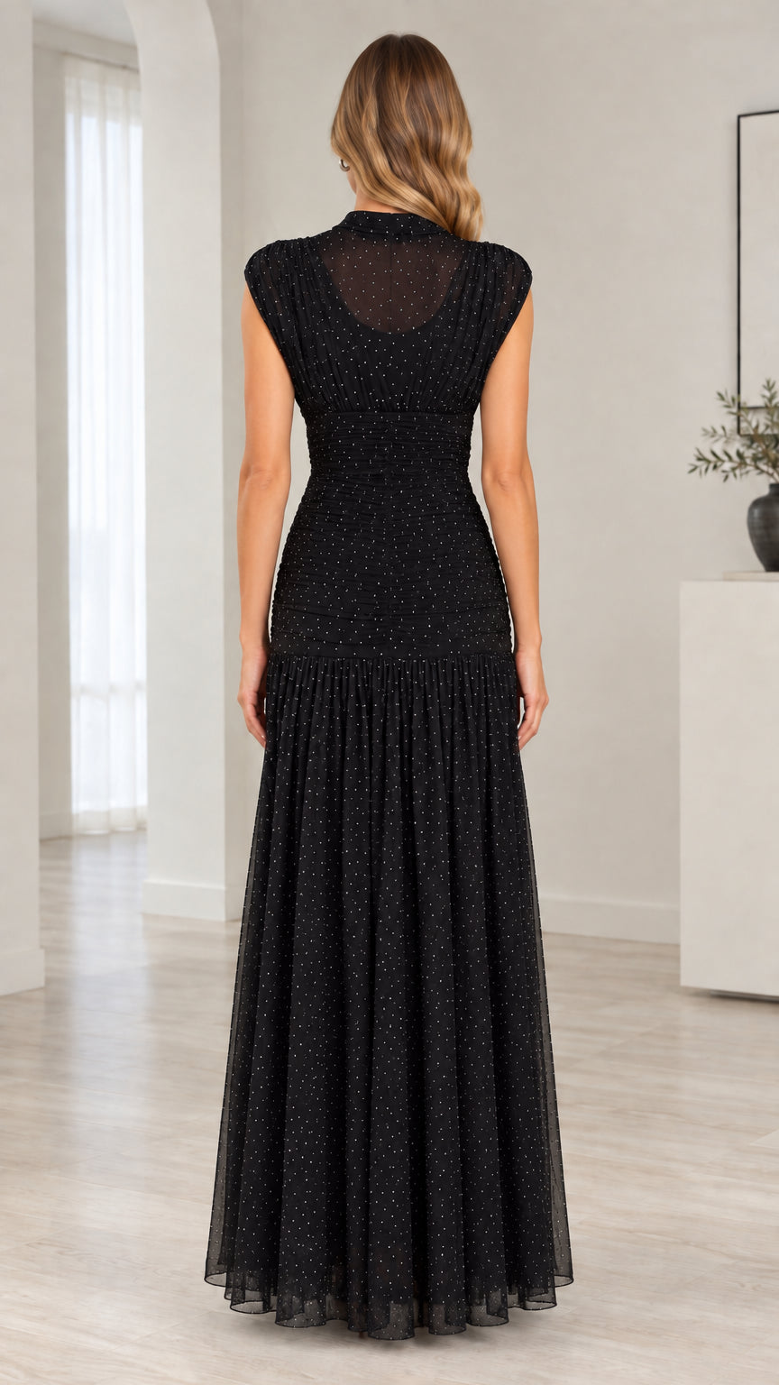 Back view of model wearing black ruched bodice sheer mesh maxi dress