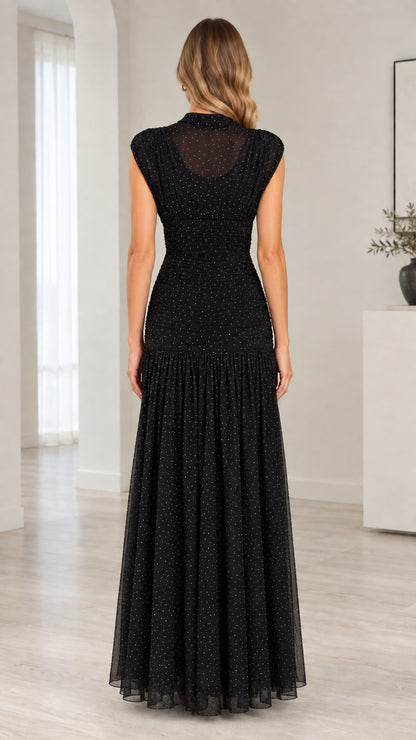 Back view of model wearing black ruched bodice sheer mesh maxi dress