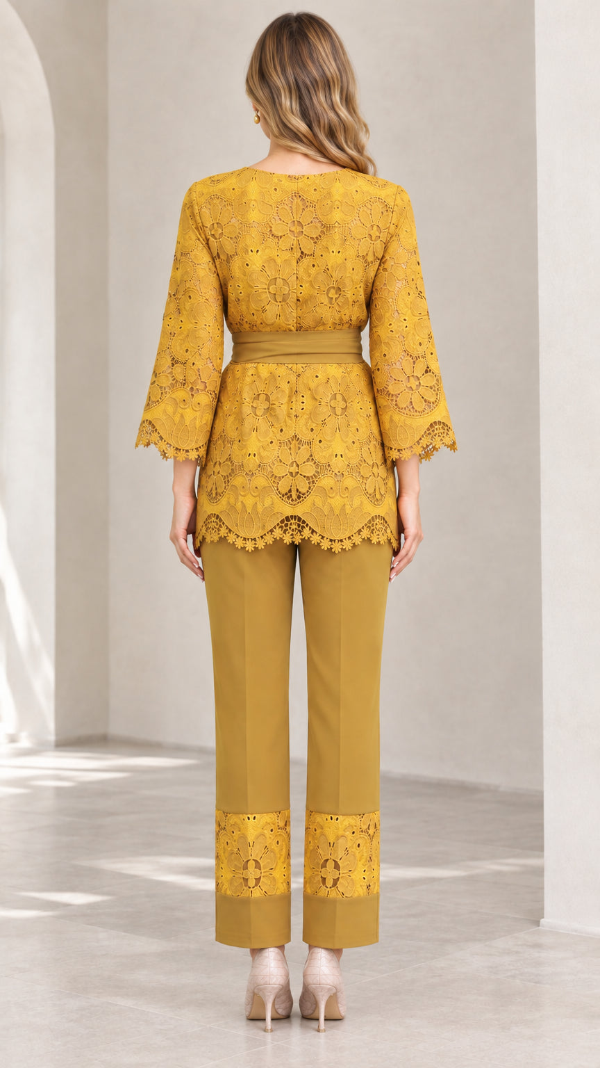 Back view of woman wearing mustard yellow belted lace top and straight-leg trousers