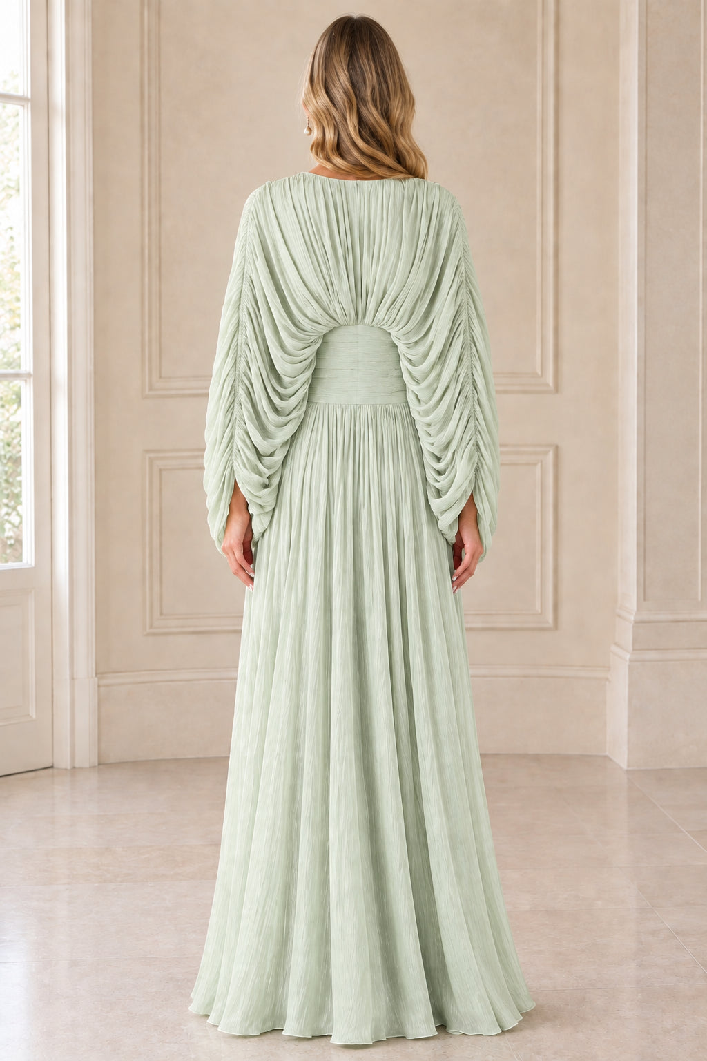Back view of model in Sage Green pleated cape sleeve gown showing back waist detail
