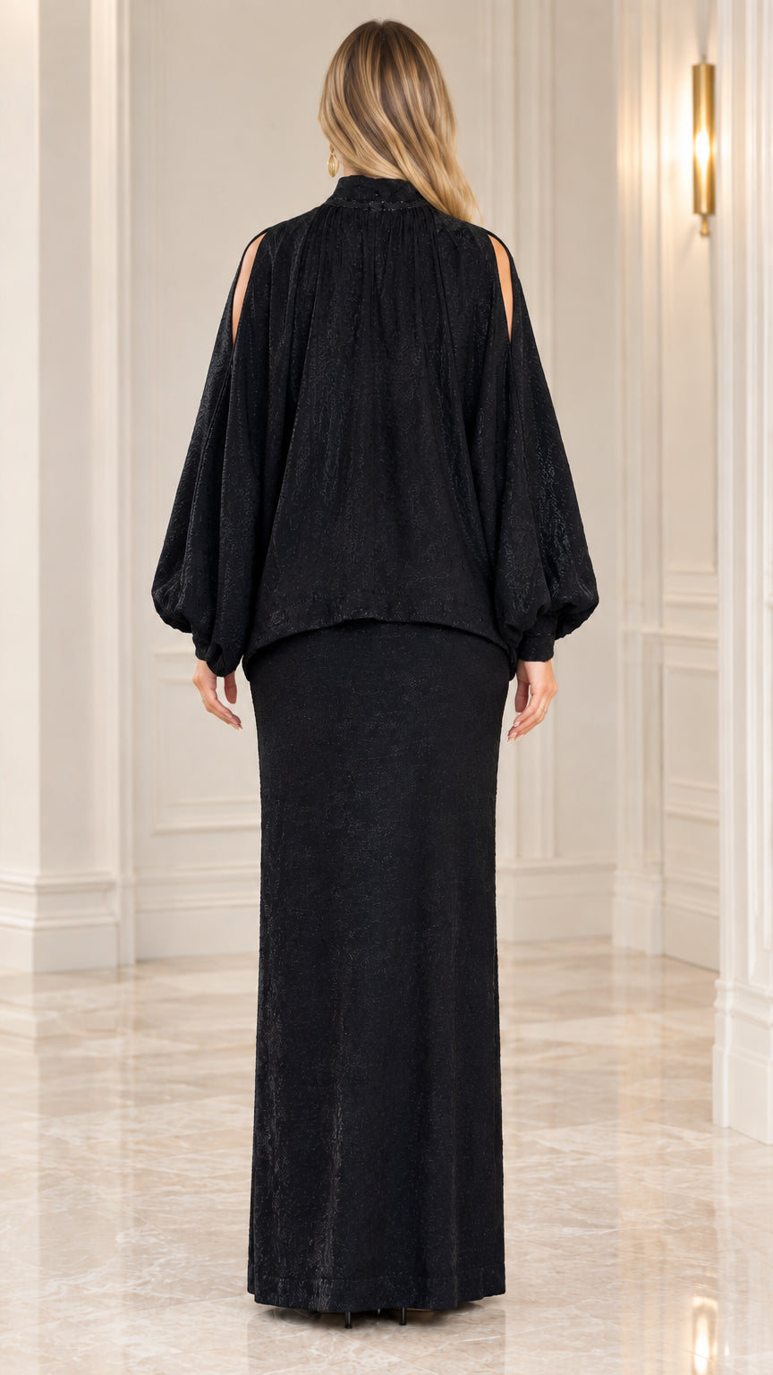 Back view of model wearing black draped high-low top and maxi skirt set