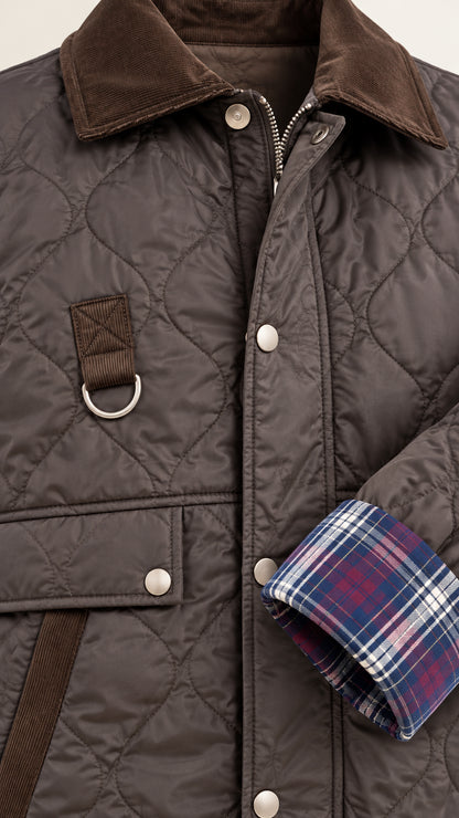 Detailed close-up of dark brown quilted jacket showing corduroy collar, snap buttons, and plaid cuff lining