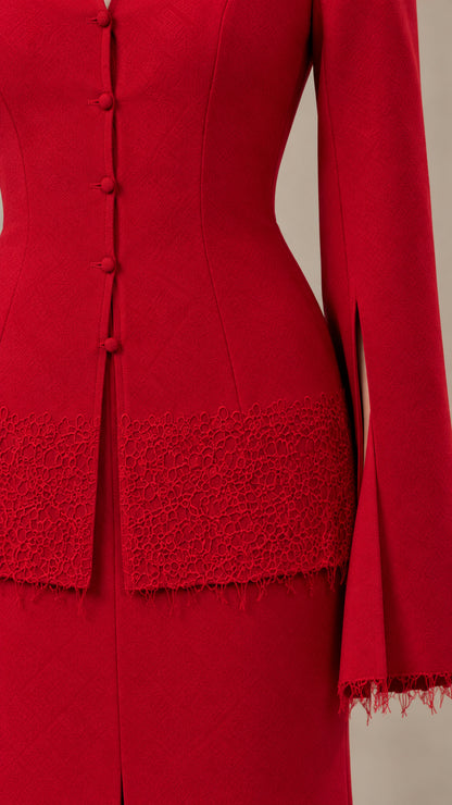 Close-up detail of the red blazer covered buttons, slit sleeve, and lace trim