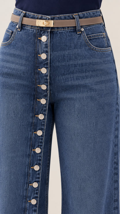 Close-up detail of high waist, belt loops, and vertical front button placket on denim