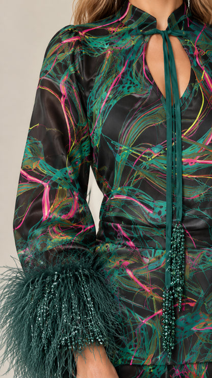 Close-up detail of keyhole tie neckline, beaded cords, and feather cuffs in Emerald Black