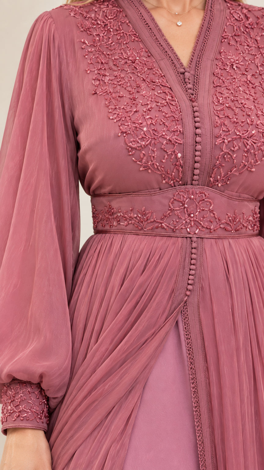 Close-up of intricate embroidery and beaded waistband detail on dusty rose dress