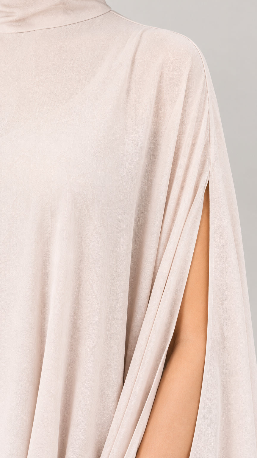 Close-up detail of high neckline and slit cape sleeve in champagne