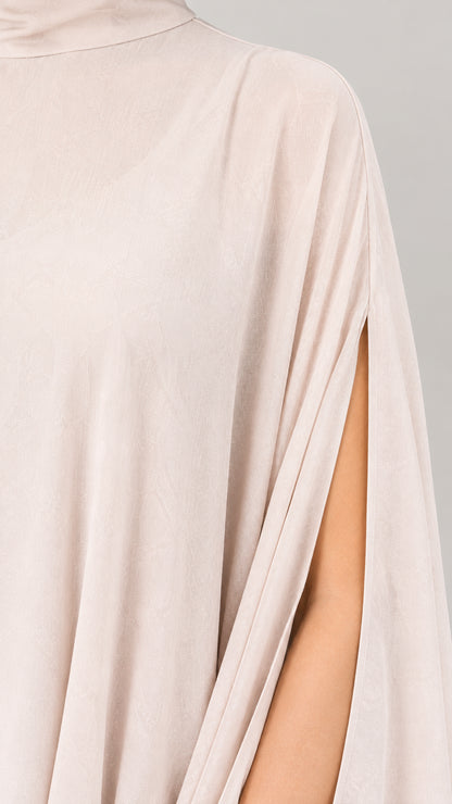 Close-up detail of high neckline and slit cape sleeve in champagne