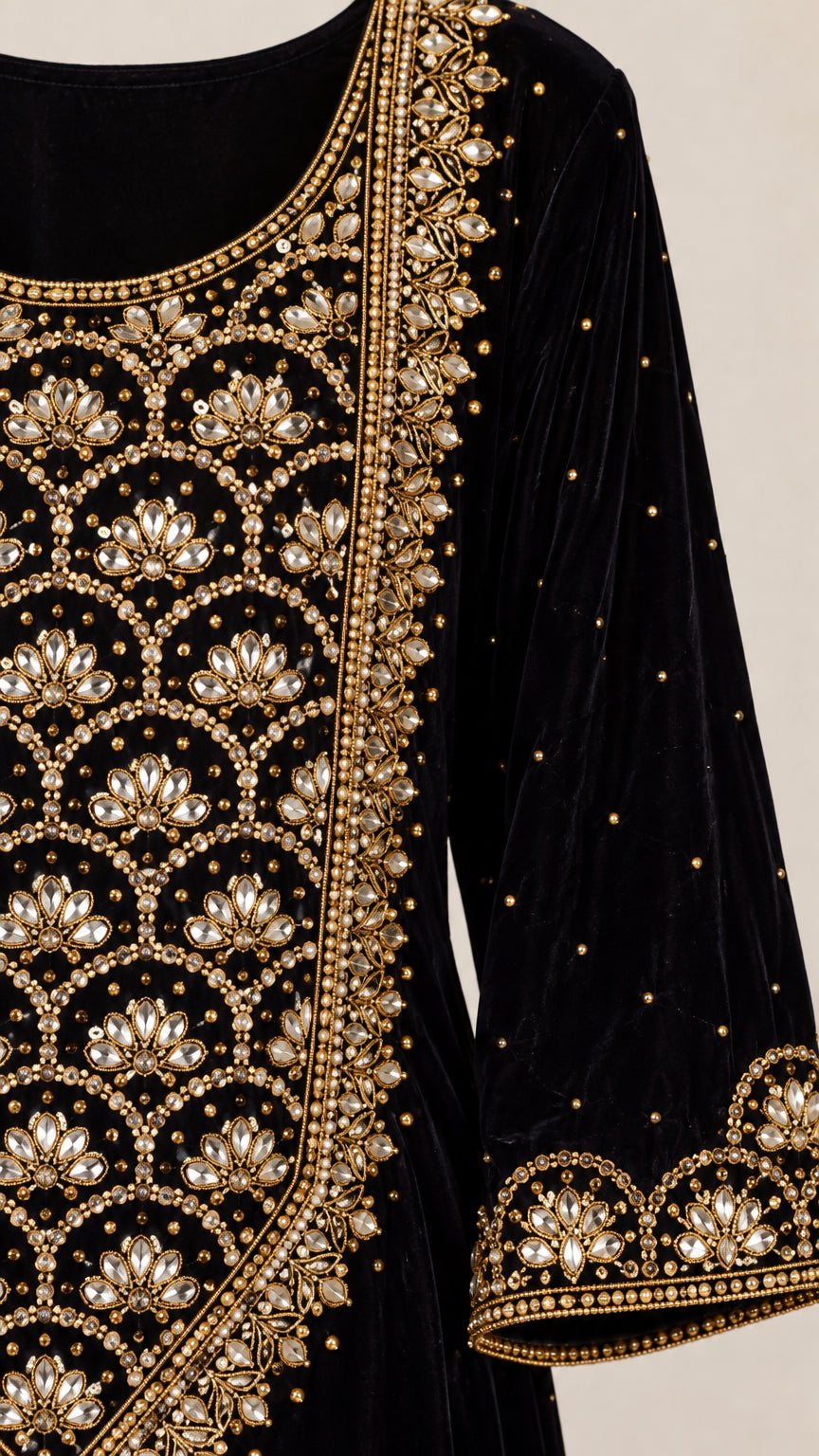 Close up view of intricate gold embroidery and beadwork on black velvet