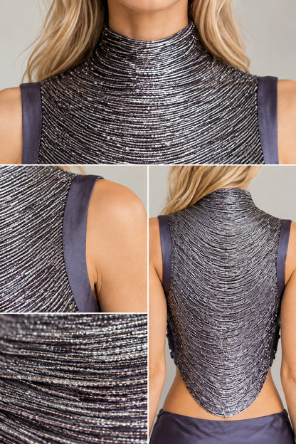 Close-up details of the textured mock neckline, sleeveless armholes, and curved back hem