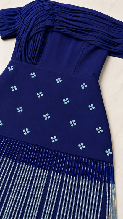 Close-up detail of pleated neckline, beaded floral motifs, and linear fringe on Royal Blue gown