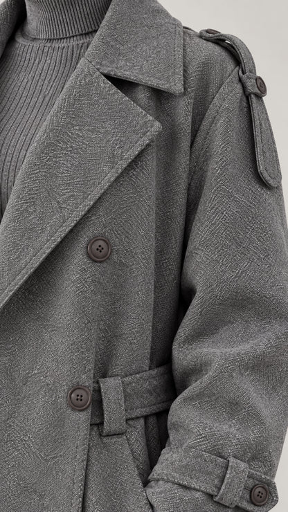 Close-up detail of grey textured fabric, lapel collar, and shoulder epaulettes