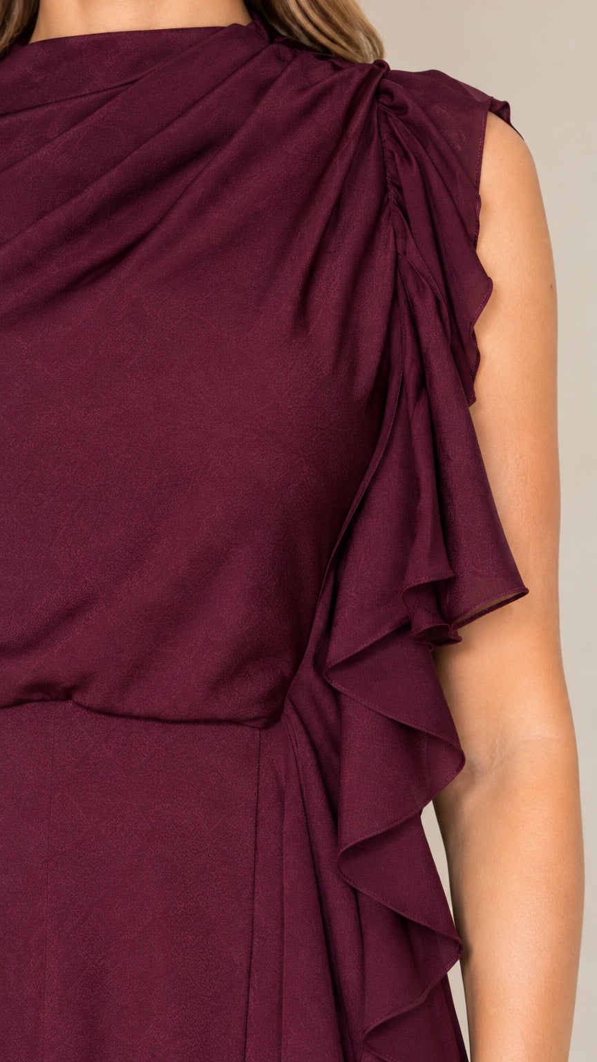 Close-up of burgundy draped neckline and cascading ruffle fabric texture