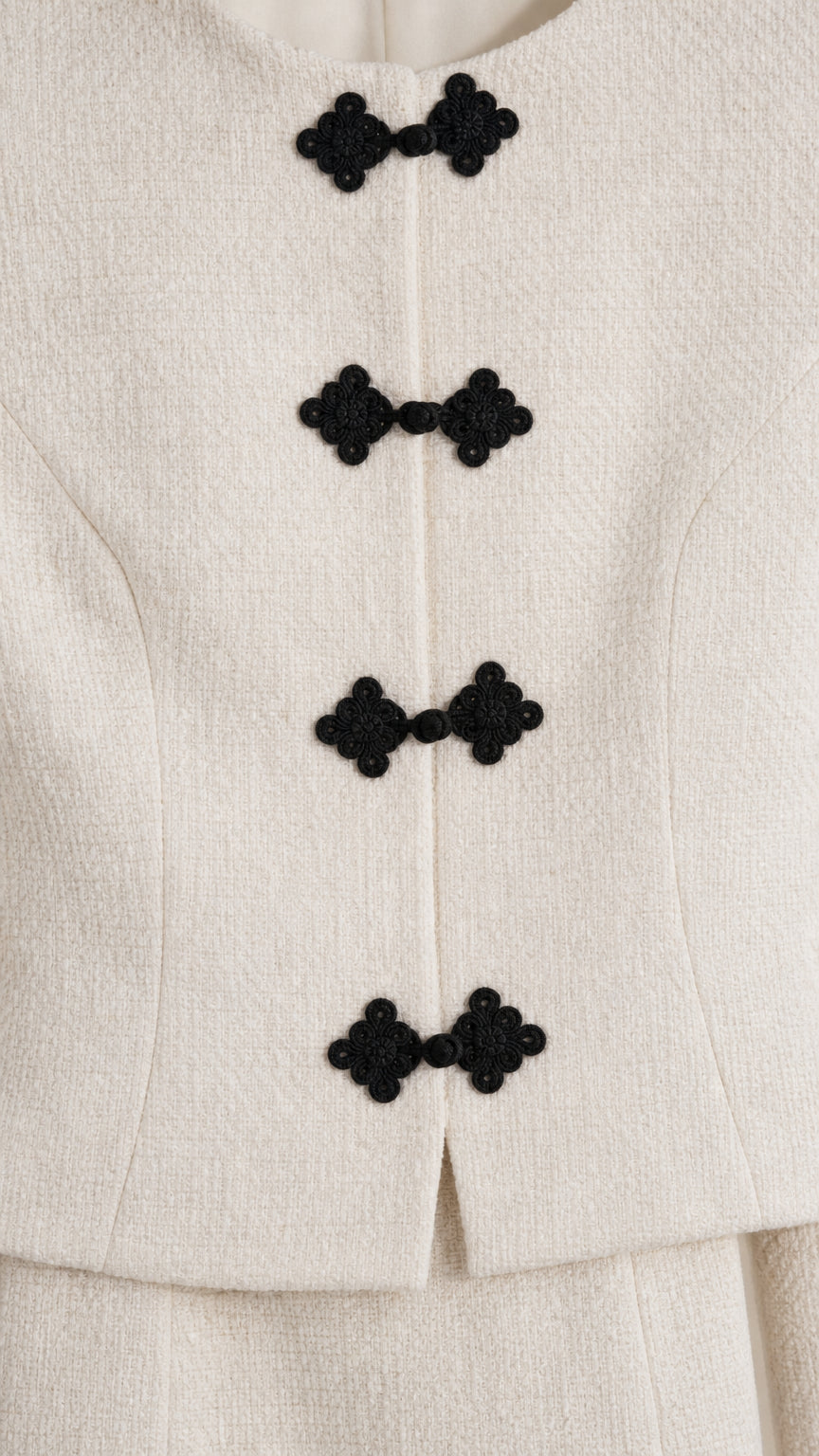 Close-up detail of textured fabric and decorative black knot closures