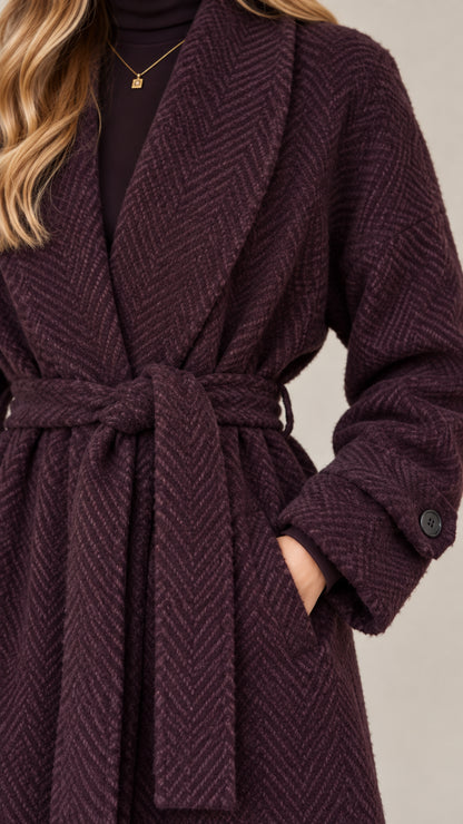 Close-up detail of herringbone textured fabric, lapel, and tie belt