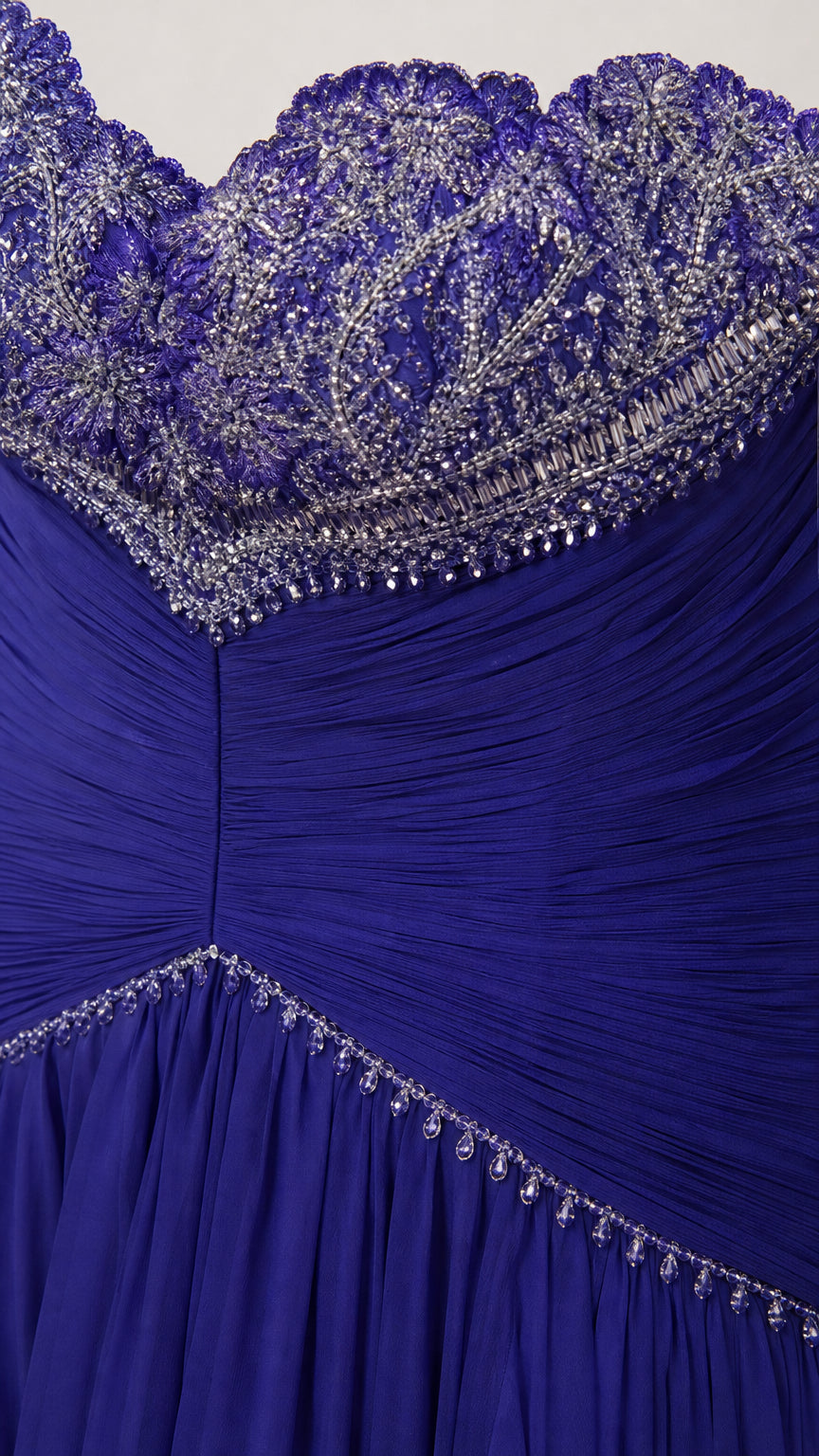 Close-up detail of intricate crystal beadwork on sweetheart neckline and pleated bodice