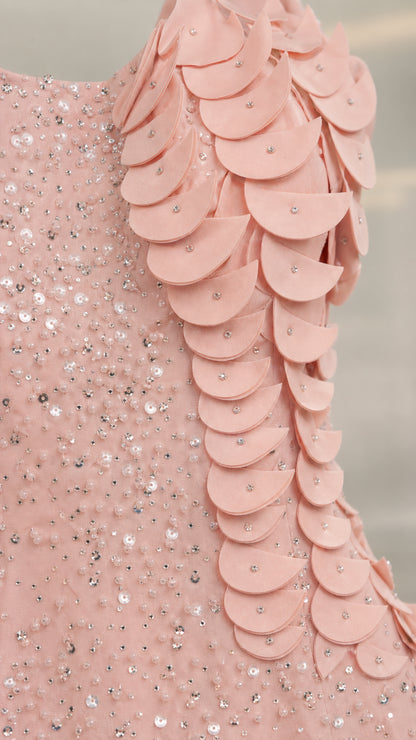 Close-up detail of blush pink sequin embellishments and 3D layered fabric petals