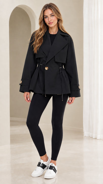 Front view of model wearing black short drawstring waist trench coat