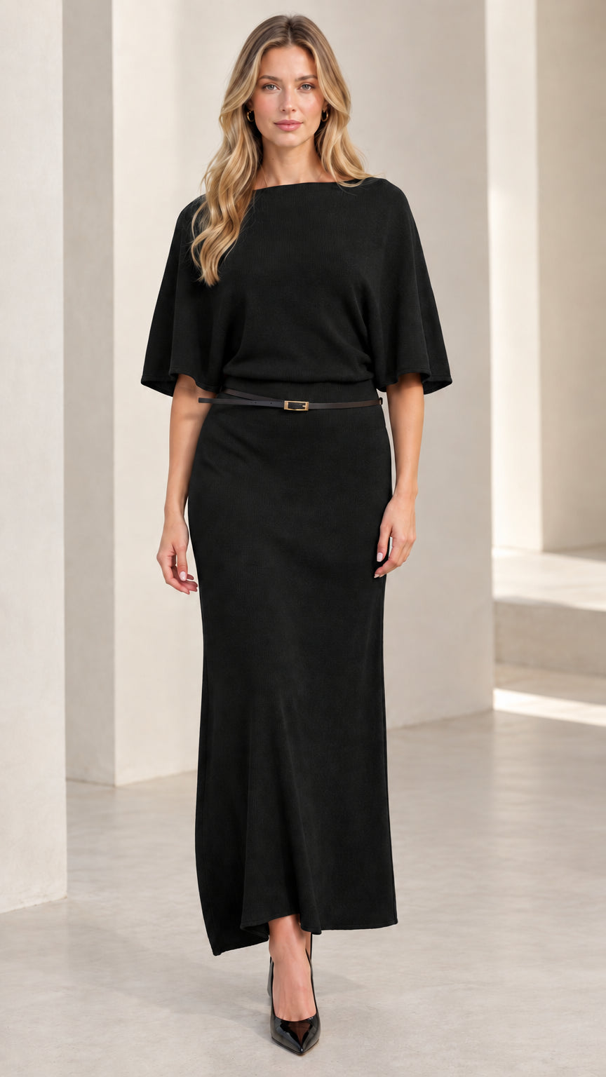 Front view of woman wearing classic black belted knit maxi dress with flutter sleeves
