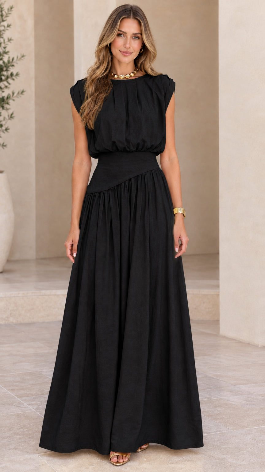 Model wearing black sleeveless pleated asymmetrical waist maxi dress